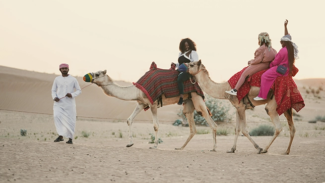 Women Riding Camels on Desert